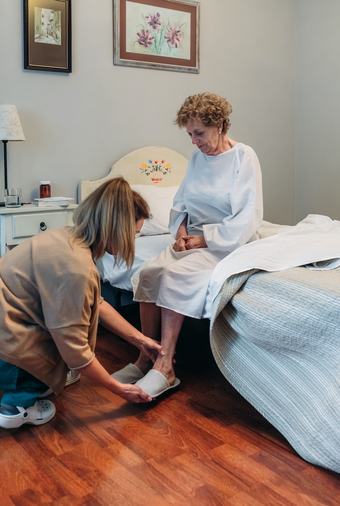 Carer wearing slippers to elderly patient