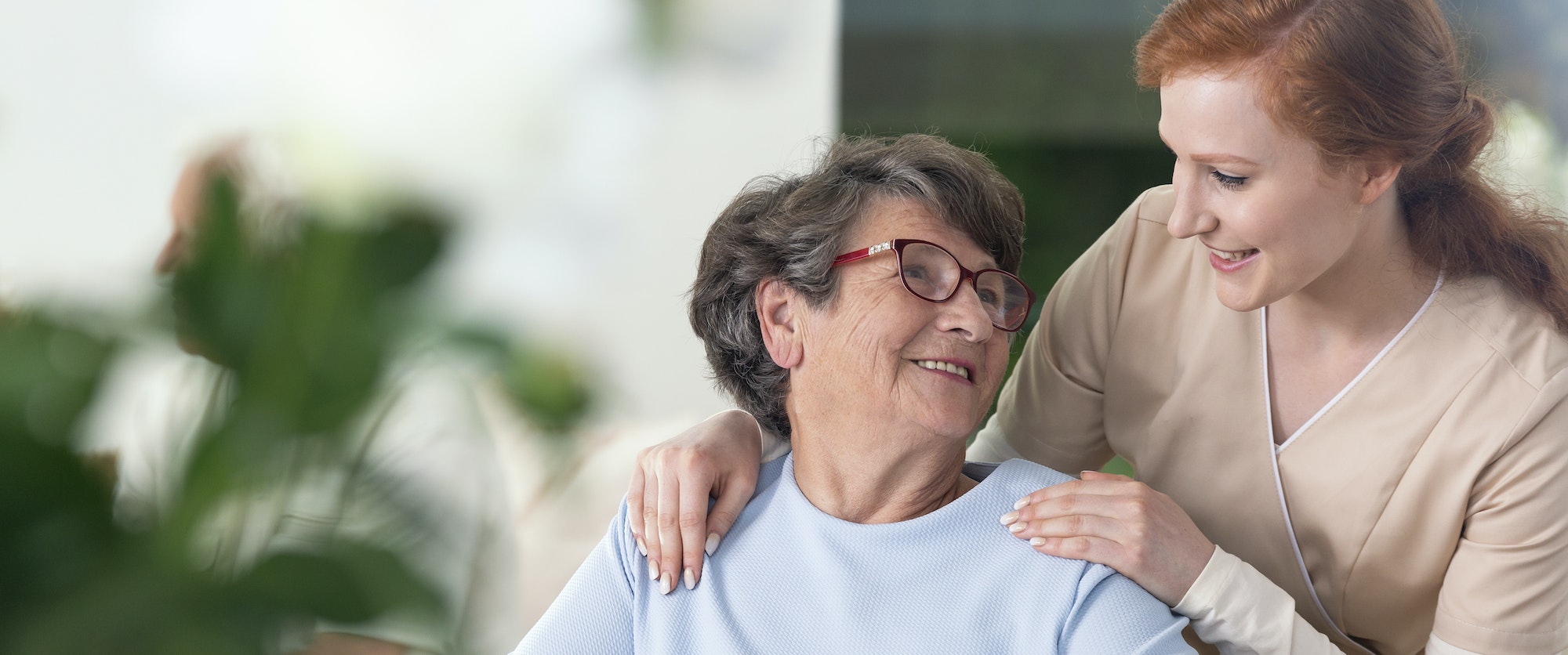 Close-up of a tender caregiver with her hands on the shoulders o