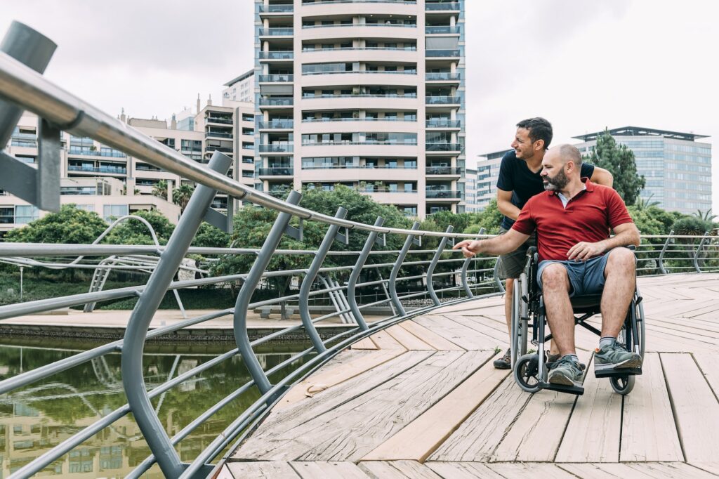 man in a wheelchair talking to his friend